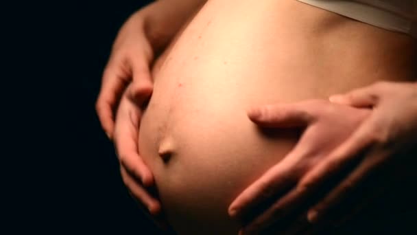 Female and male hands on  pregnant tummy - Materiał filmowy, wideo