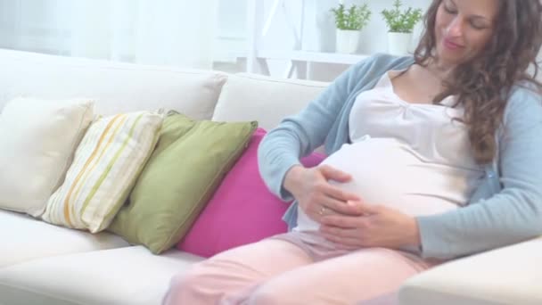 pregnant woman resting on  sofa - Materiał filmowy, wideo