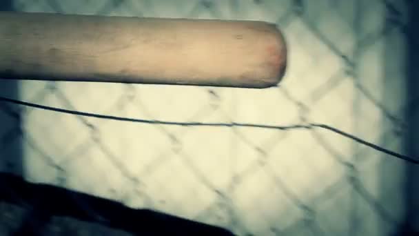 Kij baseballowy z naciskiem na ogrodzeniem z drutu - Materiał filmowy, wideo