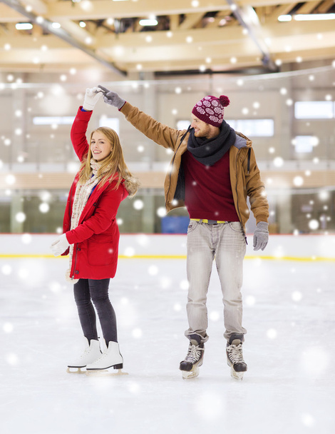 feliz pareja cogida de la mano en pista de patinaje - Foto, Imagen