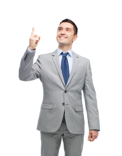 happy businessman in suit pointing finger up - Fotó, kép
