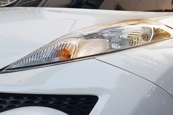ζωντανή προβολείς του λευκό αυτοκίνητο στο ηλιοβασίλεμα στην οδό - Φωτογραφία, εικόνα