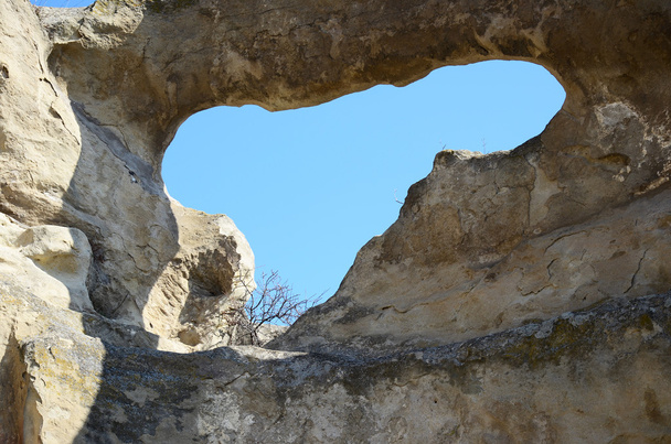 Błękitne niebo przez dziurę w ścianie w starej jaskini miasta Upliscyche, Gruzja - Zdjęcie, obraz