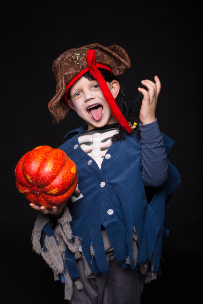 Adorable young boy dressed in a pirate outfit, playing trick or treat for Halloween. Studio portrait over black background - Foto, imagen