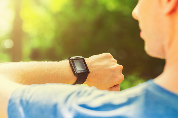 Man looking at his smart watch outside - Foto, imagen