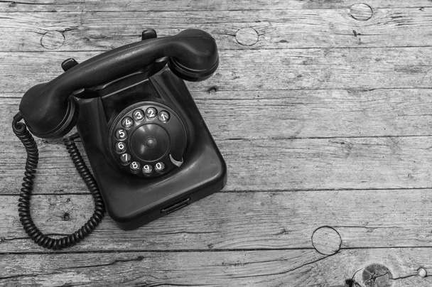 Vieux téléphone sur fond en bois noir et blanc
 - Photo, image