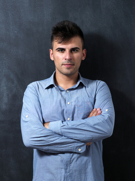 Portrait of a serious young man standing against chalkboard - Fotoğraf, Görsel