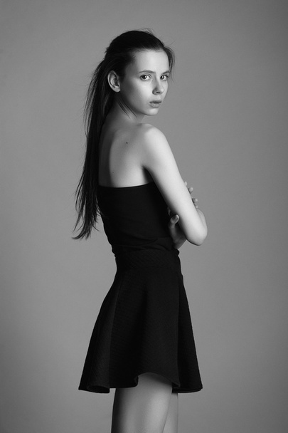 beautiful young model in elegant black dress posing in the studi - Foto, imagen