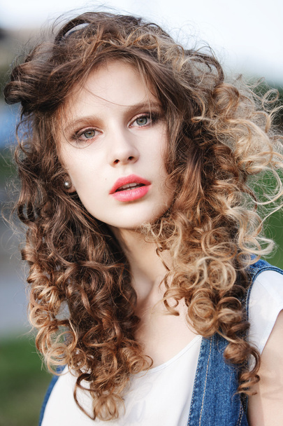 Nahaufnahme Porträt eines schönen jungen Mädchens mit lockigem braunem Haar - Foto, Bild