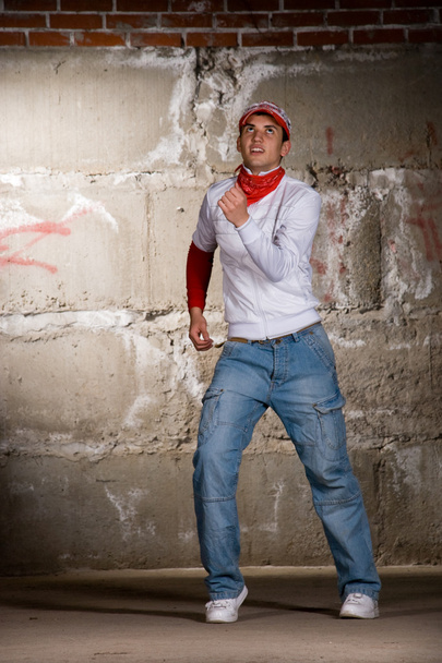 Hip hop boy dancing in modern style over grey brick wall - Foto, Imagem