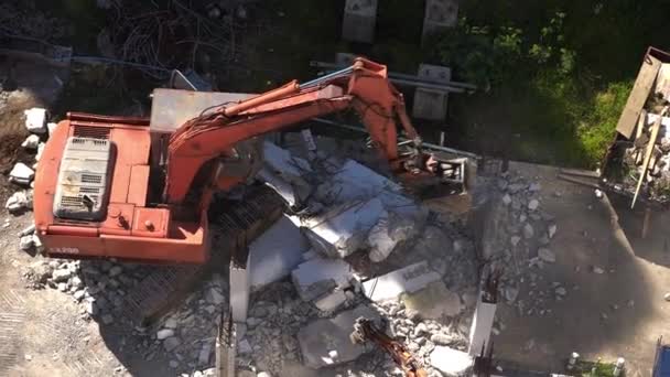 Koparka w pracy niszcząc betonową ścianę - Materiał filmowy, wideo
