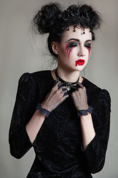 Young beautiful gothic woman with white skin and red lips. Halloween makeup. - Foto, Bild