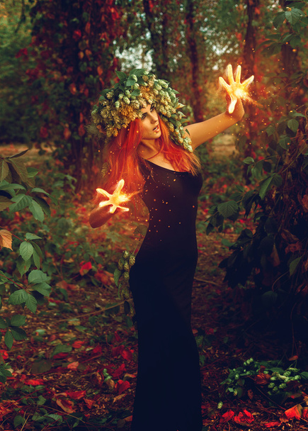 fantastic young witch conjures in the forest - Fotografie, Obrázek