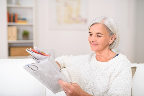 Happy Senior Lady Reading a Magazine at the Couch - Foto, Imagen