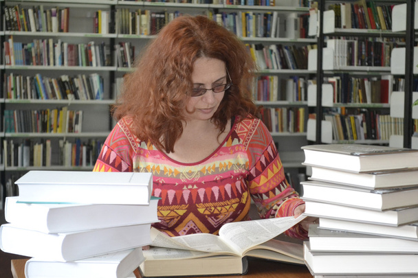 Femme liste les pages du livre dans la bibliothèque
 - Photo, image