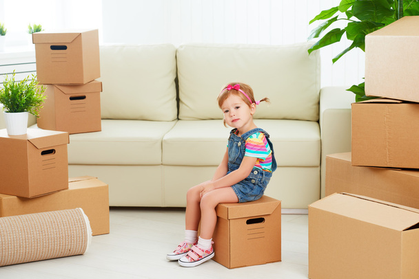 Переезд в новую квартиру. счастливый ребенок и картонная коробка
 - Фото, изображение