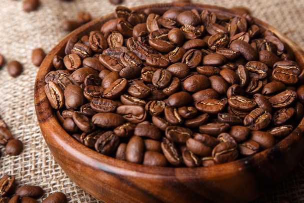 Coffee beans in a wooden dish on bag - Фото, зображення