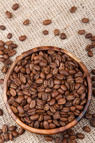 Grãos de café em um prato de madeira no saco
 - Foto, Imagem