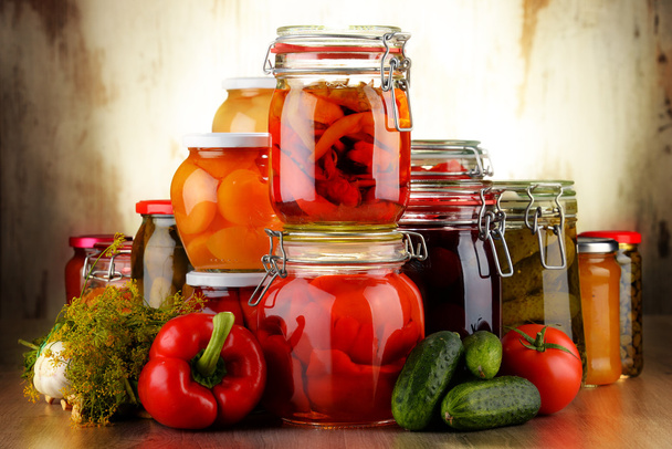 Gläser mit eingelegtem Gemüse und fruchtigem Kompott - Foto, Bild