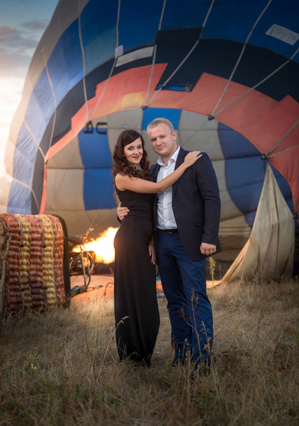 pareja romántica abrazándose contra el globo aerostático en el prado
 - Foto, Imagen