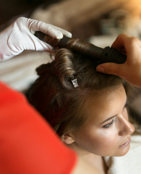 Gros plan de coiffeur utilisant le fer à friser sur belle blonde wo
 - Photo, image