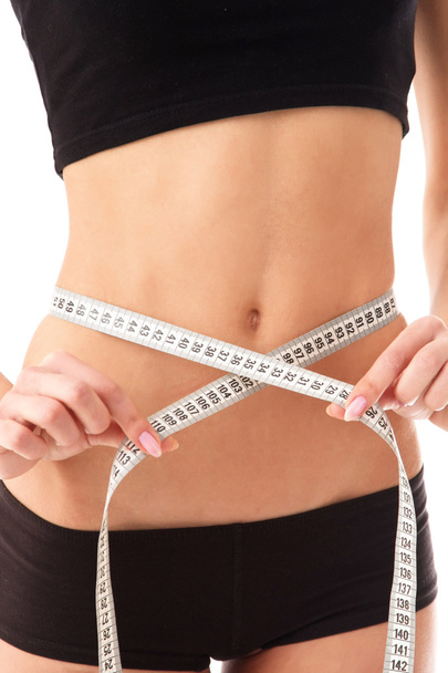 woman measure her waist belly by metre-stick. - 写真・画像