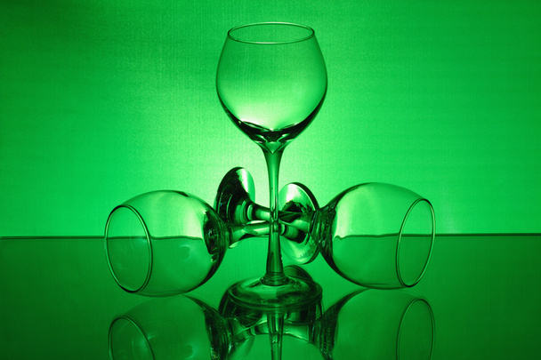 Three wineglasses with a green light - Foto, Imagen