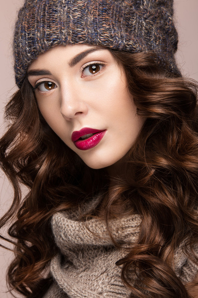 Beautiful girl with gentle makeup, curls in brown knit hat. Warm winter image. Beauty face. - Фото, изображение