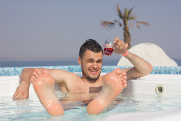 attrayant homme reposant dans la piscine avec un cocktail
. - Photo, image