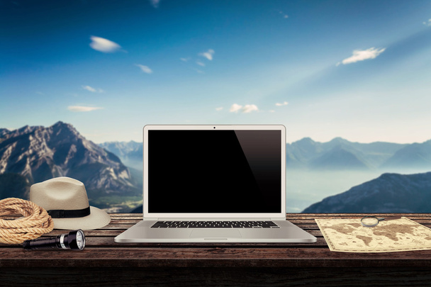 witte laptop kaart hoed touw fakkel op de tabel met bergen in de achtergrond mockup presentatie - Foto, afbeelding