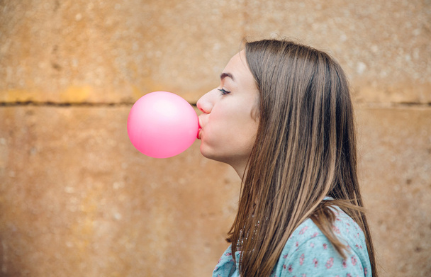 Jonge tienermeisje blazen roze kauwgom - Foto, afbeelding