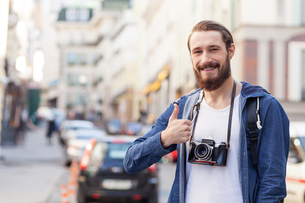 Cheerful young hipster guy is traveling across town - Фото, зображення