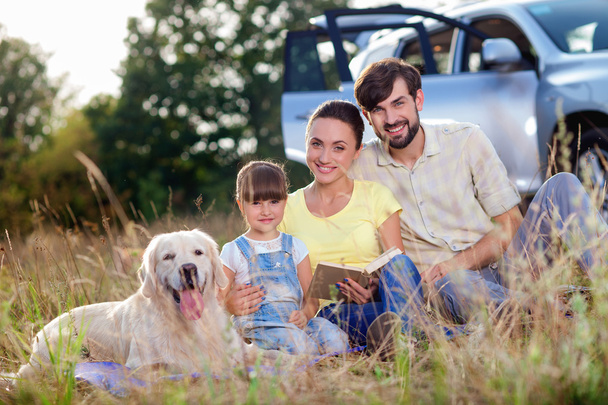 Cheerful parents and child with pet in trip - Photo, image