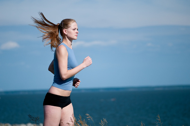νέος αθλητισμός γυναίκα που τρέχει σε ηλιόλουστη ημέρα - Φωτογραφία, εικόνα