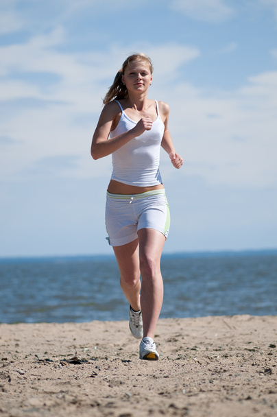 Sport woman running in sea coast - 写真・画像