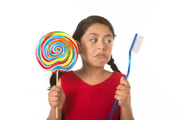 cute female child holding big spiral lollipop candy and huge too - Fotografie, Obrázek