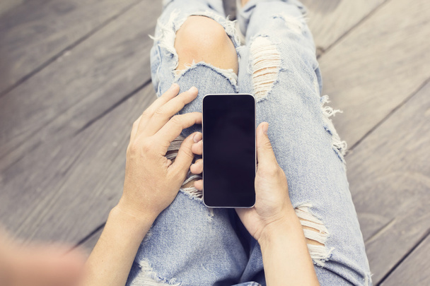 Girl in jeans with smartphone - Φωτογραφία, εικόνα