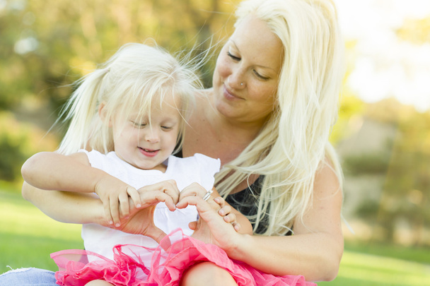 Petite fille avec mère faisant forme de coeur avec les mains
 - Photo, image