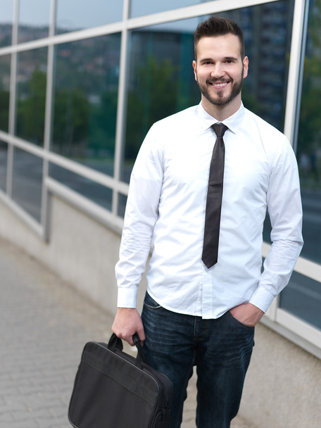 Friendly and smiling handsome businessman in front of building - Foto, afbeelding