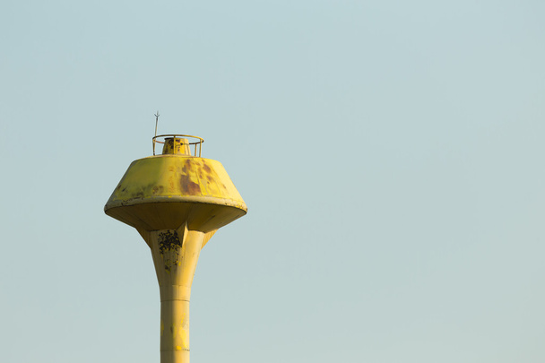 vanha keltainen vesisäiliö torni tyhjällä taivaalla
 - Valokuva, kuva