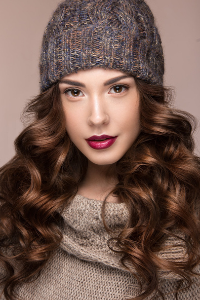 Beautiful girl with gentle makeup, curls in brown knit hat. Warm winter image. Beauty face. - Valokuva, kuva