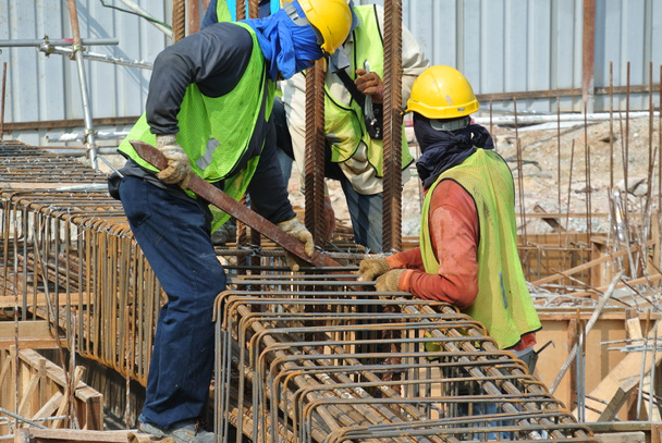 Trabalhadores da construção civil fabricando barra de reforço de feixe de terra
 - Foto, Imagem