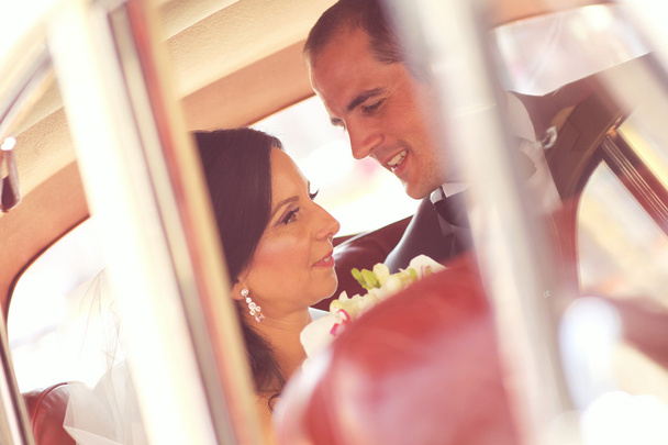 Beautiful bride and groom smiling in car - Foto, Imagen
