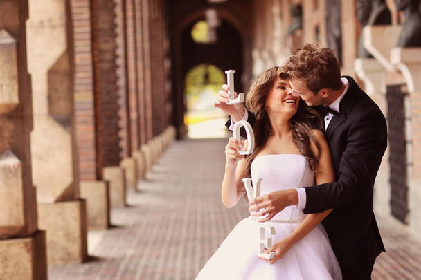 Beautiful bride and groom embracing in the city - Foto, Bild