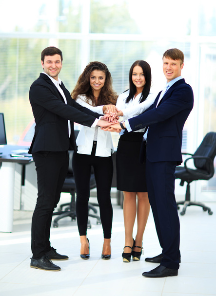 Groep van mensen uit het bedrijfsleven stapelen zich op hun handen samen in de w - Foto, afbeelding
