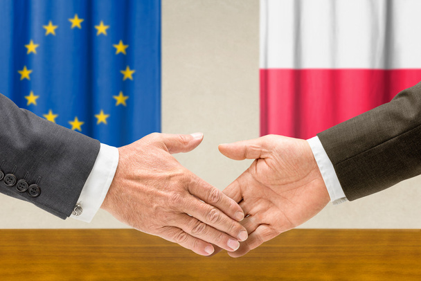 Representatives of the EU and Poland shake hands - Photo, Image