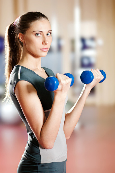 Beautiful sport woman doing exercise with dumbbell - Фото, зображення