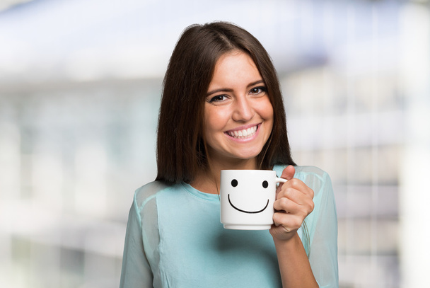 Smiling woman holding smiling cup - Photo, image