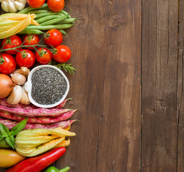 Ruwe chia zaden in een kom en verse groenten - Foto, afbeelding
