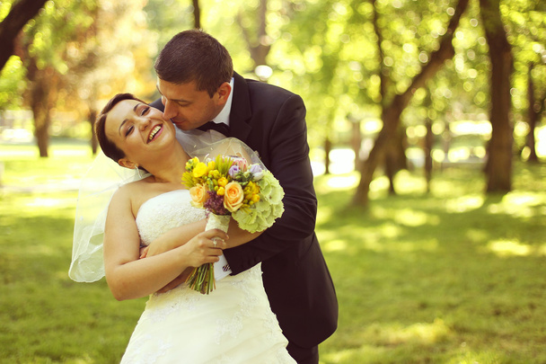Happy bridal couple embracing in the park - Foto, immagini